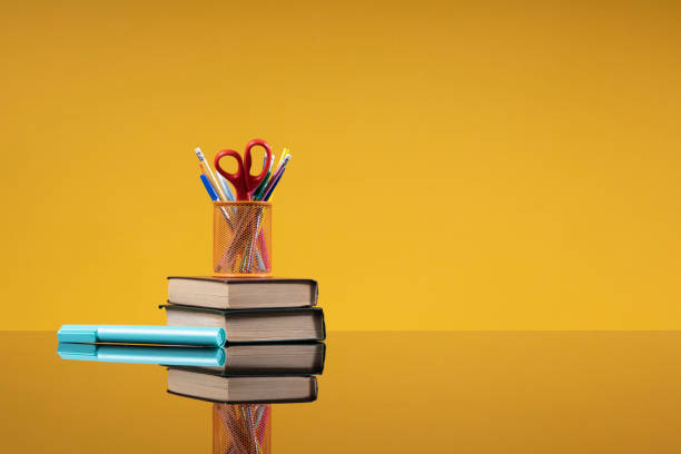 istock School accessories as a back to school concept. Writing materials on a stack of old books and a blue marker as a background with free space for the website of the school, institute, university, article about school education 1402843928
