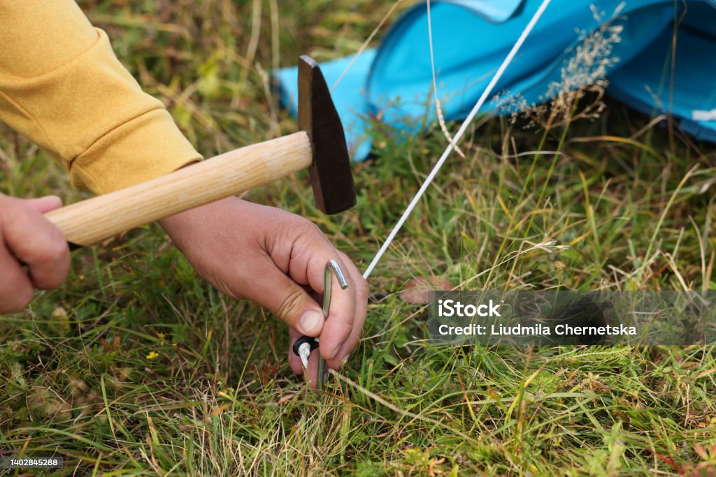 Man setting up camping tent outdoors, closeup Post - Structure Stock Photo