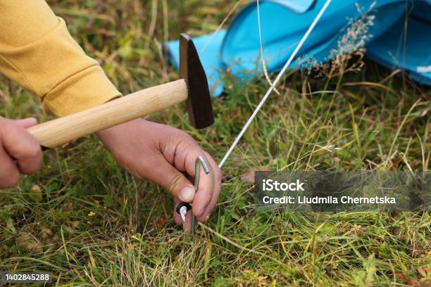 Man Setting Up Camping Tent Outdoors Closeup Stock Photo - Download Image Now - Post - Structure, Resting, Hammer