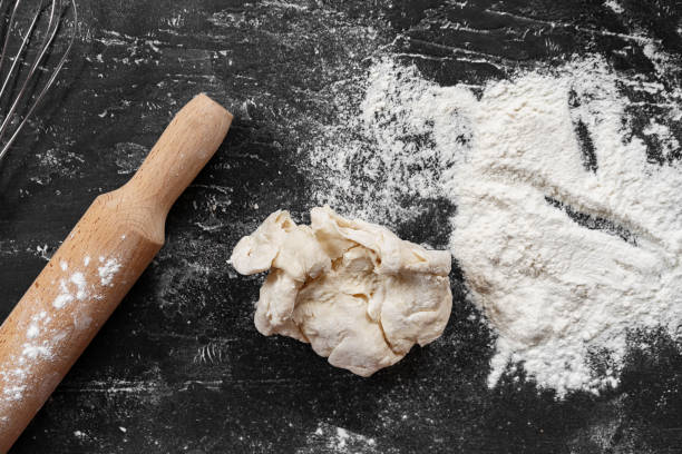 istock Scattered flour with rolling pin on black background 1402848741