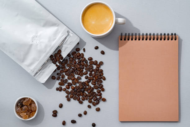 istock Cup of coffee with notebook on gray background top view 1402849880