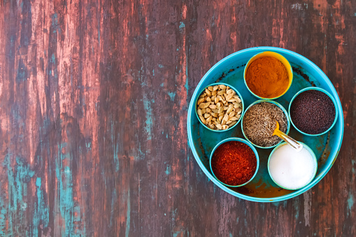 Spice box Indian masala dabba,indian spice box on wooden,Cardamom, turmeric, chilli powder, salt,mustard seeds,cumin,blur background