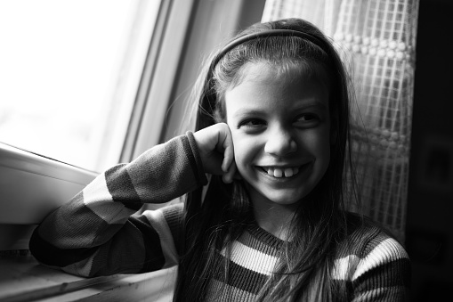 Black and white image of cute little girl who is cheerful and smiling.