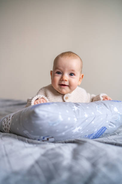 Smiling baby girl lying on bed and looking at camera