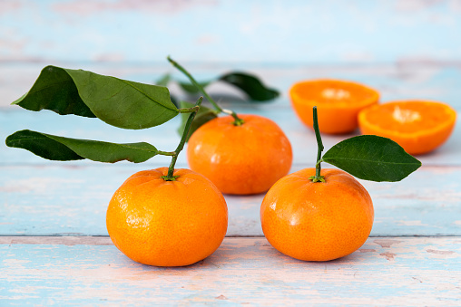 Tangerines with leaf on rustic wooden background, copy space, flat lay.