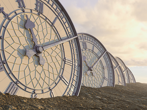 A line of half buried antique clocks made of blue iron with gold trim in a sandy gravel landscape - 3D render