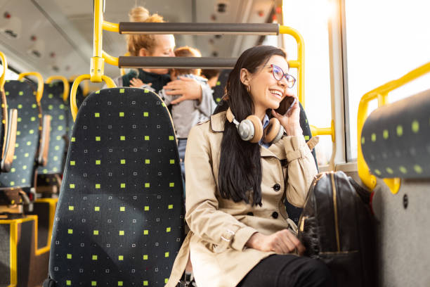donna che parla al cellulare in autobus - bus transportation indoors people foto e immagini stock