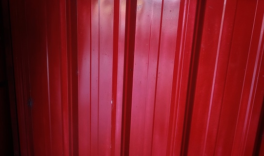 Close-up shot Red stripped metallic door for abstract texture pattern background