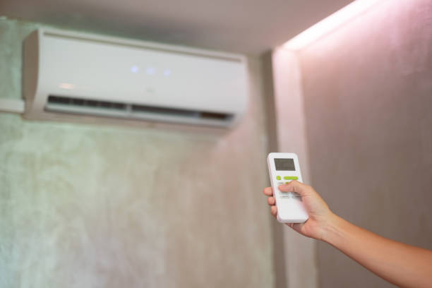 istock hand using remote controller for adjust Air conditioner inside the room of office or home 1402856324
