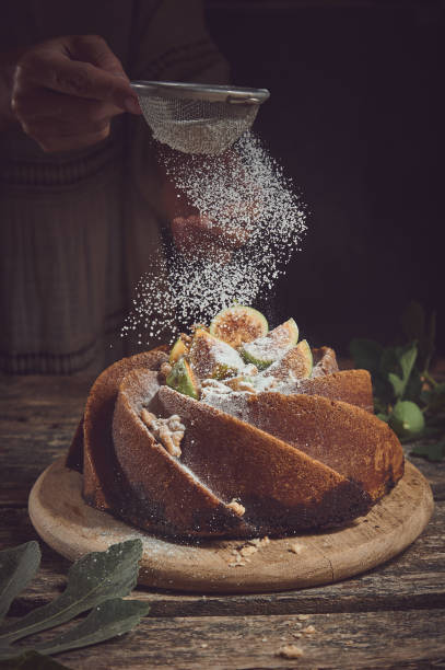 istock Unrecognizable chef sprinkling powdered sugar on fig cake 1402856341