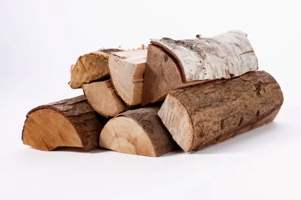 Pile of chopped birch pine and oak firewood stacked on white background in studio