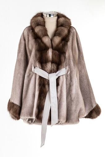 Expensive fur coats collection on a mannequin. Woman coats on white background.