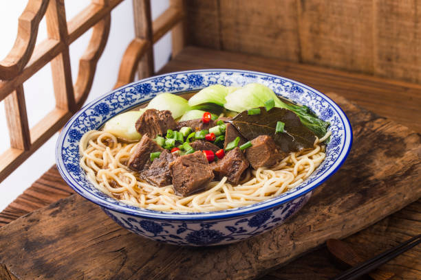 istock Spicy red soup beef noodle in a bowl on wooden table 1402858253
