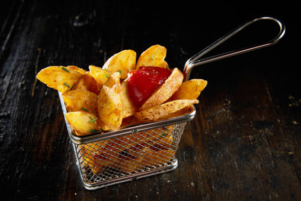 istock Fried potato wedges with ketchup in basket 1402859003