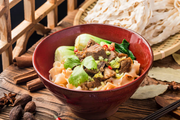 istock Spicy red soup beef noodle in a bowl on wooden table 1402859053