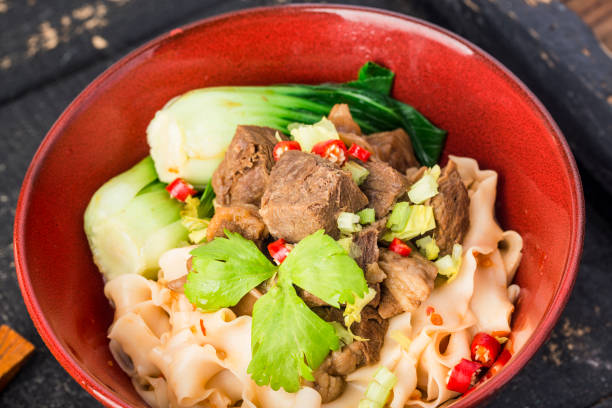 istock Spicy red soup beef noodle in a bowl on wooden table 1402859066