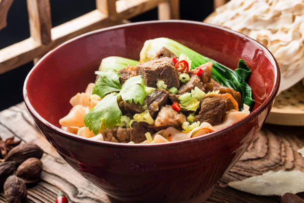 istock Spicy red soup beef noodle in a bowl on wooden table 1402859267
