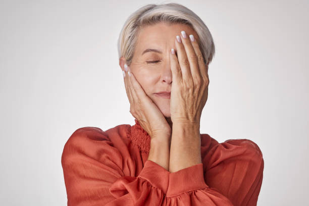 istock One mature woman suffering with a headache and looking stressed while posing against a grey copyspace background. Ageing woman experiencing anxiety and fear in a studio 1402859719