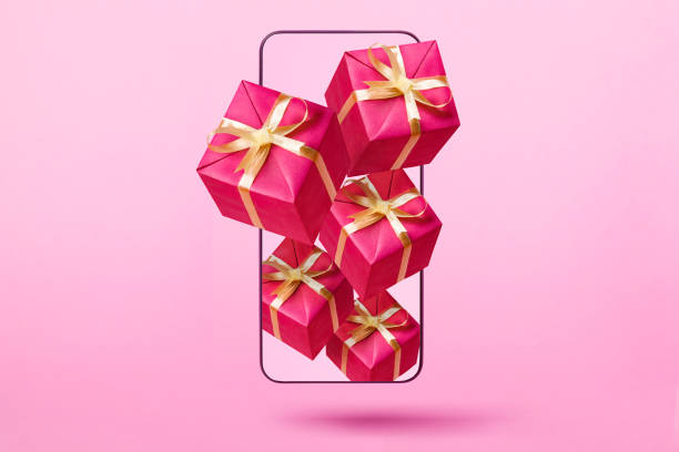 istock Flying gift box from smartphone on pink background. 1402860259