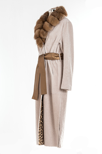 Expensive fur coats collection on a mannequin. Woman coats on white background.
