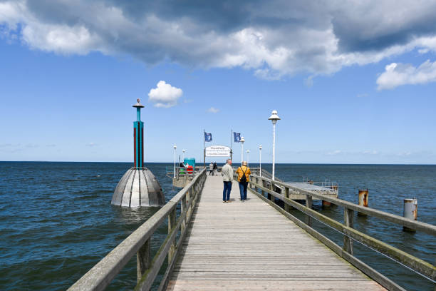 Zinnowitz, Germany, May 12, 2022 - Lowered diving bell on the pier in Zinnowitz, some unidentified tourists in the background