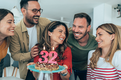 Young woman celebrating her 32nd birthday with friends at home