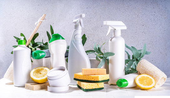 Eco friendly organic cleaning concept. Eco-friendly cleaner utensils - eco brushes, tools sponges, natural cleaning products, soda, soap, lemon, vinegar, bottles with green leaves on white background