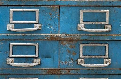 close up of a retail display of old, rusted, weathered, blue metal file boxes for sale at a salvage yard, Long Island, New York
