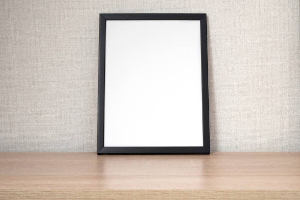 istock Black photo frame with blank white space on wooden shelf, desk. Mockup, template space for text 1402860915