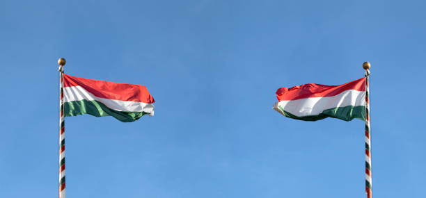 bandera húngara o bandera de hungría ondeando contra el cielo azul, vista panorámica - hungarian flag fotografías e imágenes de stock