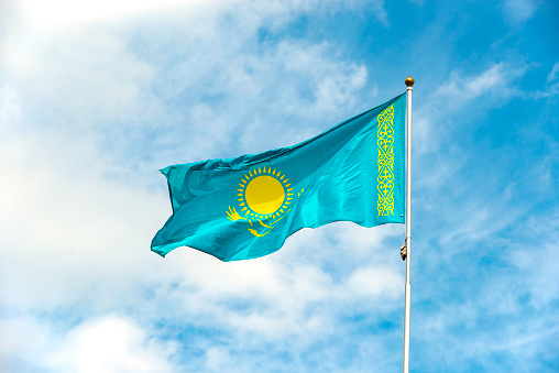 Flag of Kazakhstan waving against blue sky