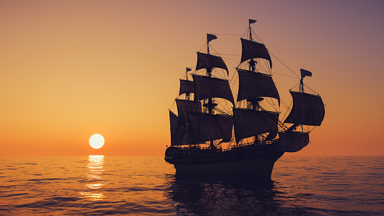 Old warship sailing the sea at dawn.