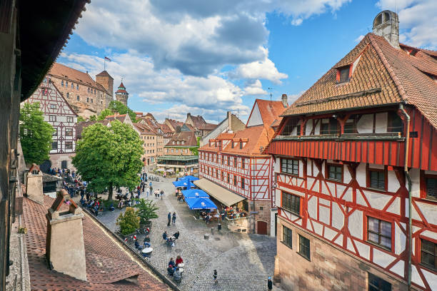 Nuremberg Nuremberg, Germany - May 28, 2022: Crowd at the Tiergärtnertor in Nuremberg. On the left part of the old city wall and on the right the Albrecht Dürer house. In the background the towers of the Kaiserburg. kaiserburg castle stock pictures, royalty-free photos & images