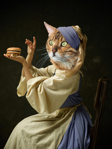 Tasting burger. Graceful female model like medieval person in vintage clothing headed by cat head isolated on dark background. Comparison of eras, artwork, renaissance style. Contemporary collage.