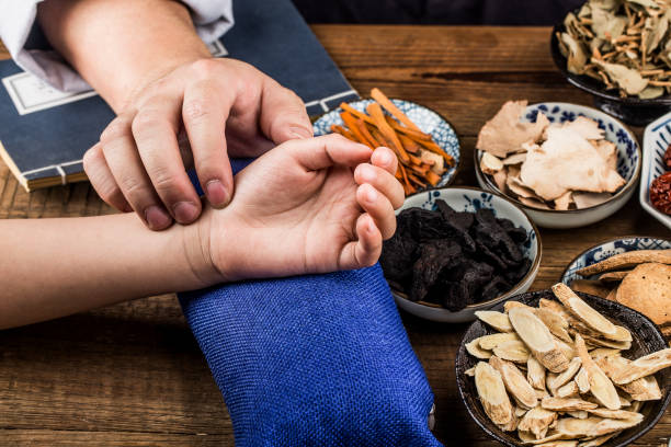 il vecchio dottore della medicina tradizionale cinese al polso del paziente - traditional chinese medicine foto e immagini stock