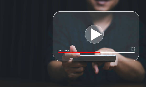 istock Man hand holding smartphone and watching for live streaming for Video streaming on internet and multimedia technology concept. 1402865754