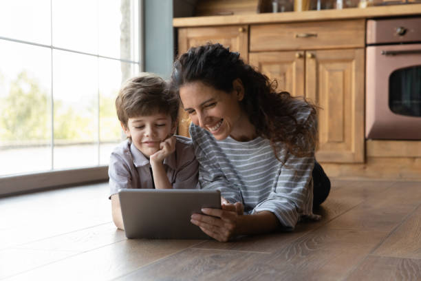 istock Happy young mother using tablet with little kid. 1402867189