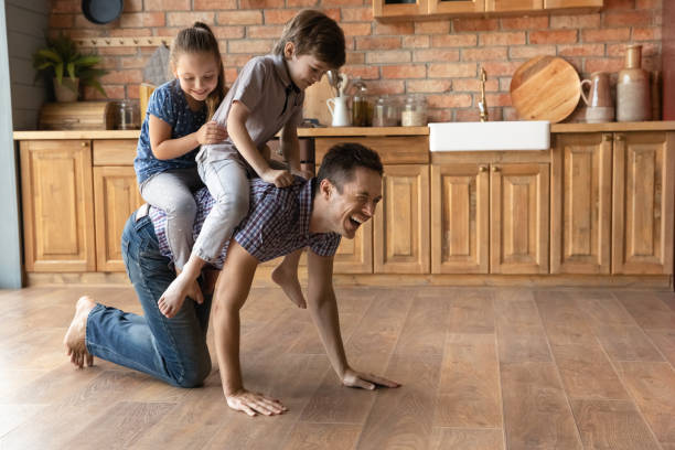 istock Cheerful young father playing with children in old-fashioned kitchen. 1402867202