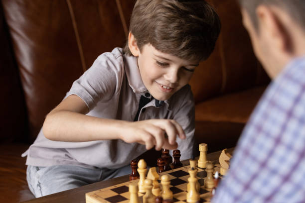 istock Happy little kid boy playing chess with caring father. 1402867205
