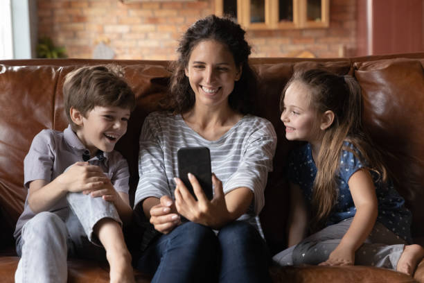 istock Happy young mother using cellphone with kids. 1402867220