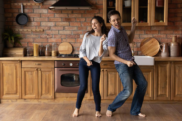 istock Laughing young hispanic family couple dancing in kitchen. 1402867242