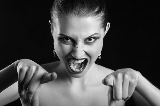 angry beautiful woman point at camera screaming, monochrome