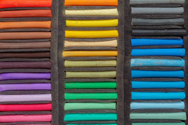 A set of colored pastel crayons for the artist in a foam lodgment, top view