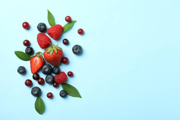 istock Delicious fresh berry mix on blue background 1402870857
