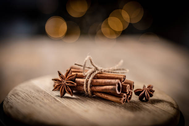 Star anise and cinnamon sticks tied with rope lying on wooden plate