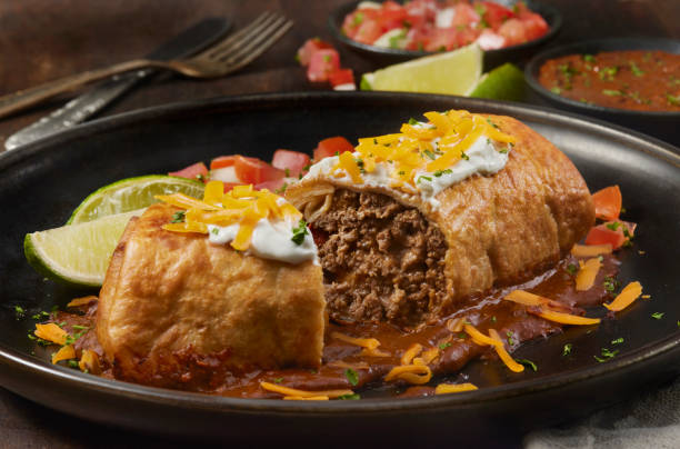 Beef  Chimichanga with Mole Sauce Beef  Chimichanga. A Deep Fried Beef Burrito with Cheddar Cheese Sour Cream Pico de Gallo and Mole Sauce enchilada stock pictures, royalty-free photos & images