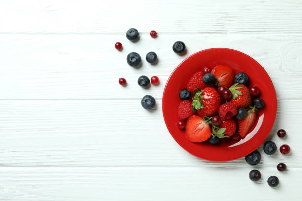 istock Bowl with berry mix on white wooden background 1402872318