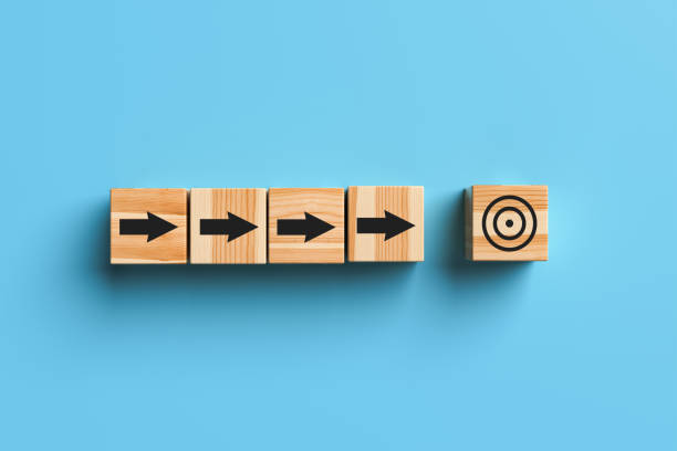 istock Wooden blocks with arrows and a target on a blue background. 1402873410