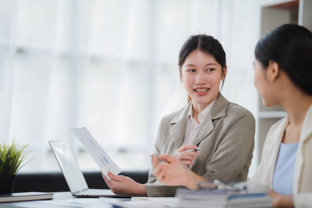 istock Two Businesswomen Having Informal Meeting In Modern Office, mentor helping apprentice explain corporate program, support teamwork concept. 1402874529