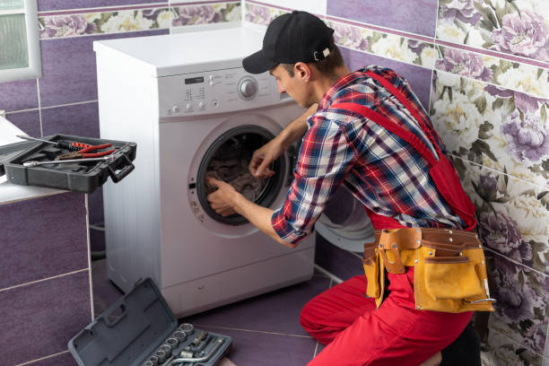 istock young serviceman checks broken washing machine loader on floor in room closeup 1402875694